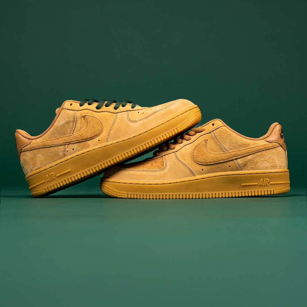 A pair of Nike SB Air Force 1 Flax Black sneakers are stacked against a green background. Enter the READ BELOW the BUTTON RAFFLE at Southside Skatepark for your chance to own this standout style.