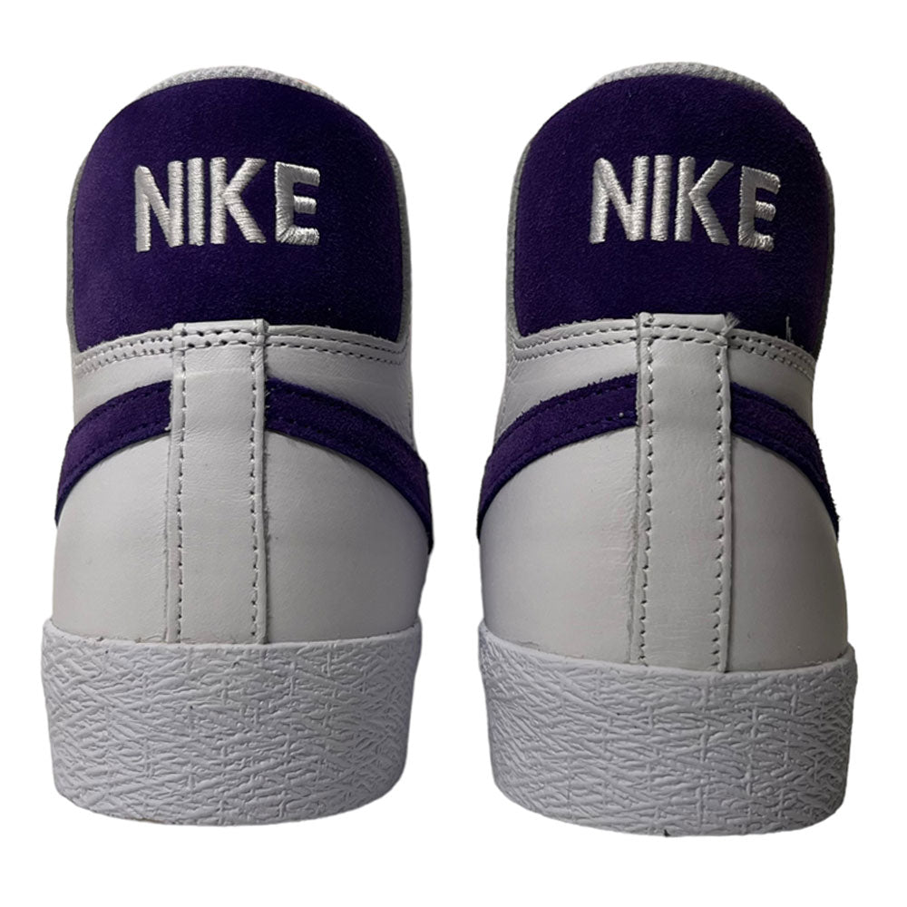 The DZ4949100 Court Purple White Blazer Mid Nike SB Leather Skateboarding Shoes feature a classic design with white and purple leather, and "NIKE" embroidered in white on the purple heel—iconic style for skateboarding.