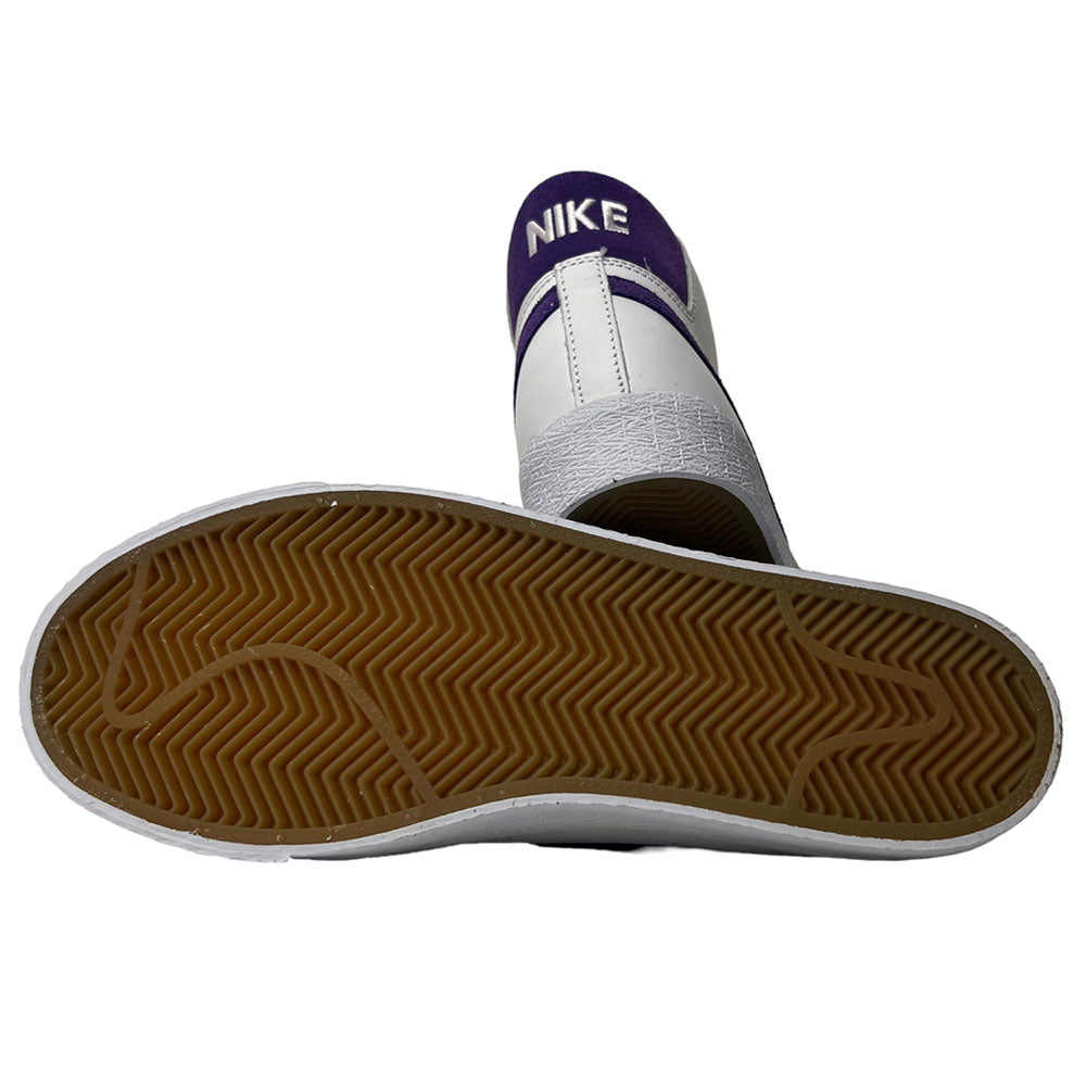 The DZ4949-100 Court Purple White Blazer Mid Nike SB Leather Skateboarding Shoes feature a white leather upper, gum rubber sole with herringbone tread, and a purple heel tab with white NIKE branding—perfect for skateboarding fans.