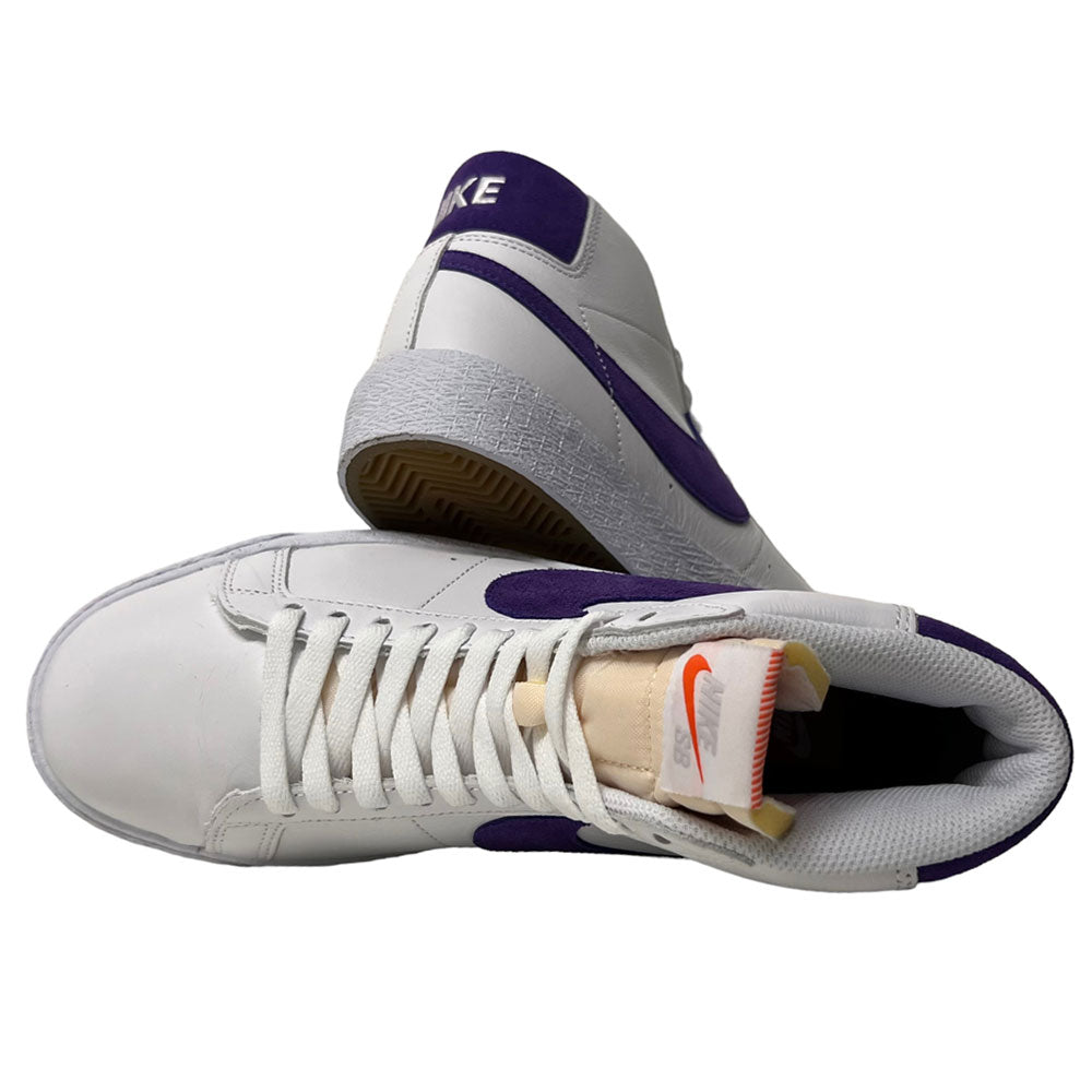 A pair of DZ4949-100 Court Purple White Blazer Mid Nike SB leather skateboarding shoes—one lies on its side, showing the outer and sole, while the other stands upright revealing the tongue with an orange Nike logo.