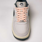 A pair of Yuto AF1 Iron Grey White Coconut Milk IO8439100 Nike SB Suede Skateboarding Shoes, featuring a light iron grey suede upper, peach laces, black accents, and “Yuto Horigome” text on the tongue—viewed from above against a plain background—blending iconic skate shoe design with signature Nike Air cushioning for lasting comfort.