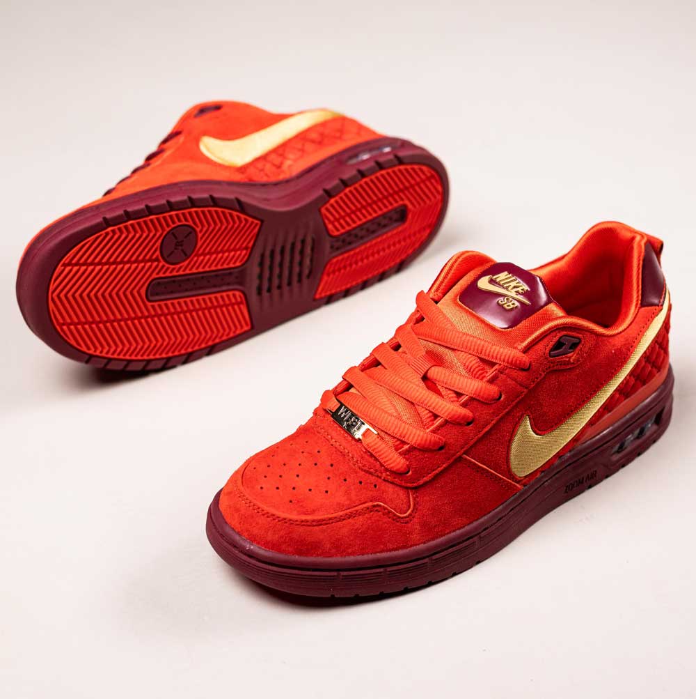 The READ BELOW the BUTTON RAFFLE Habanero Red Nike SB Paul Rodriguez 1 sneakers in bold red with gold swooshes, burgundy midsoles, and red laces are showcased—ideal for your next Southside Skatepark raffle entry.