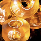 Four translucent orange Spitfire Wheels Sapphire 54mm90A Clear Orange Conical Full wheels with white printed logos and specifications.