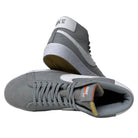 The Nike SB Blazer Mid DV5467001 White Wolf Grey Shoes showcase white swooshes and outsoles. One shoe stands upright and the other lies on its side, revealing the sole, inner lining, and tongue—all crafted for responsive cushioning.
